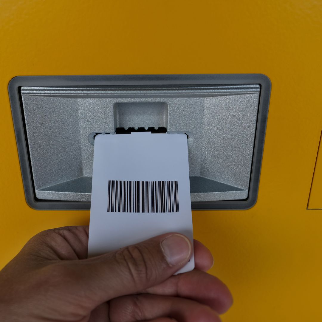 photo of someone pulling a ticket out of a machine